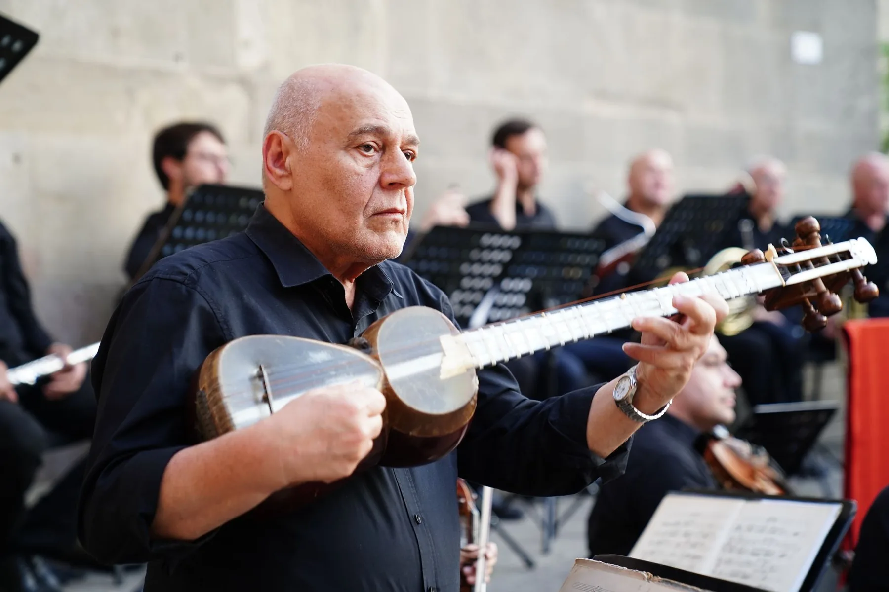 Solo musician in front of a large orchestra