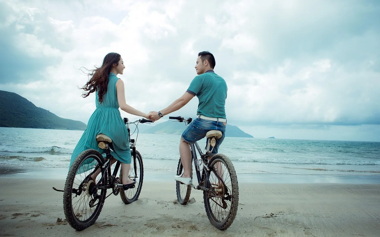Romantic couple cycling on the beach Romantic couple cycling on the beach