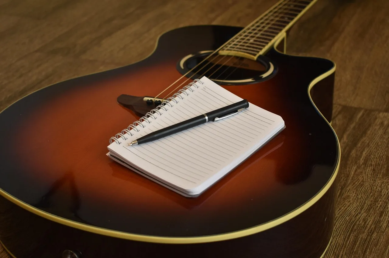 Acoustic guitar and music notebook Acoustic guitar and music notebook